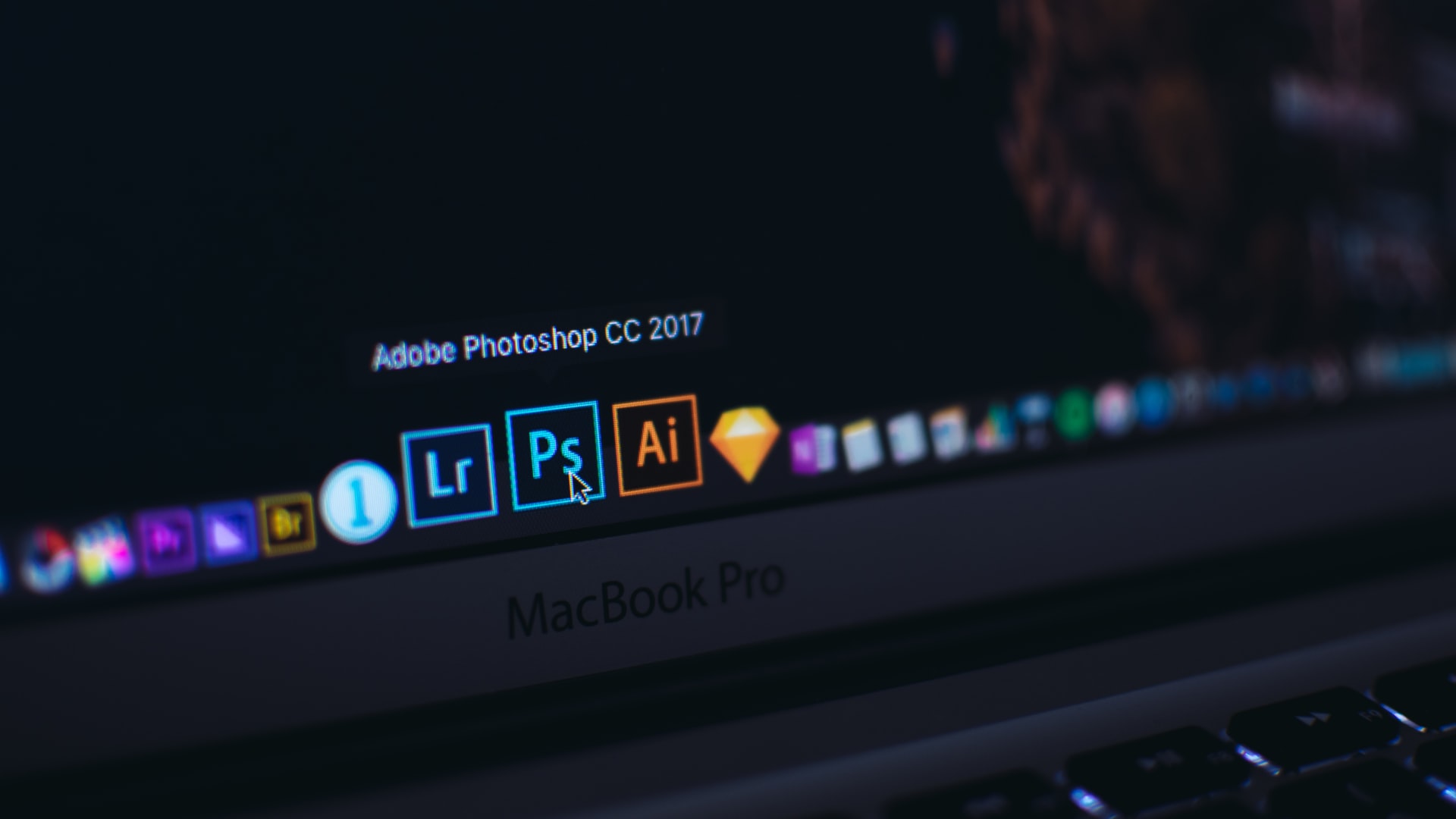 Mouse hovering over an icon of Photoshop on a Macbook Air screen.